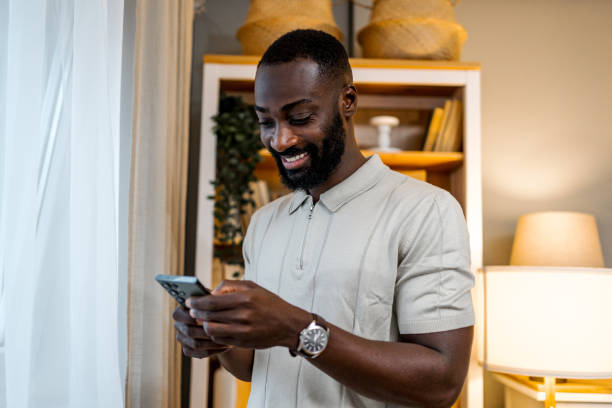 istock Young cheerful man using phone at home 2178077173