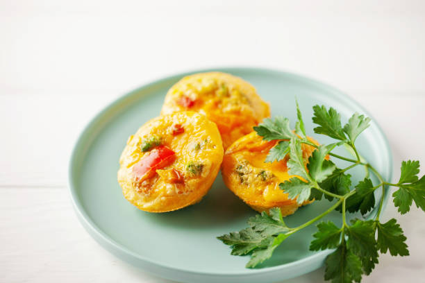 istock Egg muffins ( bites) and parsley leaves  in a plate on a gray background. 2178078176