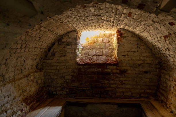 istock Brick dark dungeon. Brick-lined cellar or basement with a small window letting in some light. The brickwork appears old and weathered, suggesting a long history. 2178079733