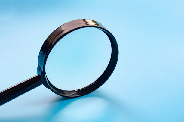 istock Side view of magnifying glass on blue cover background with customizable space for text or ideas 2178082146