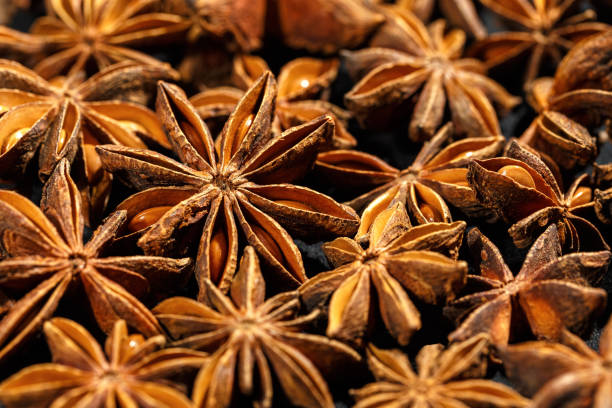 istock Brown Anise stars as pattern at sunlight, close up aromatic spices dried aniseed on black background, aesthetic food pattern, textural graphic photo, natural season condiments 2178089345