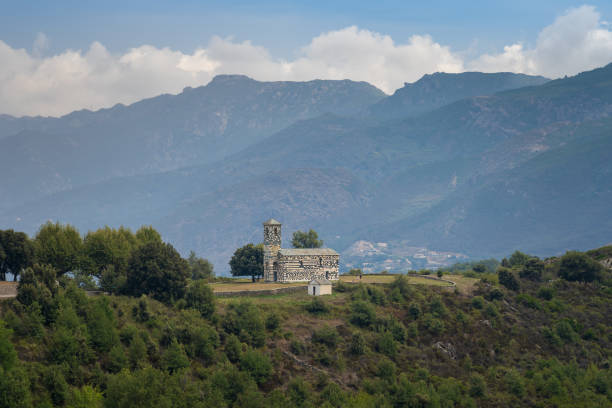 Saint-Michel de Murato church in Corsica, beautiful church seen from distance surrounded by mountains