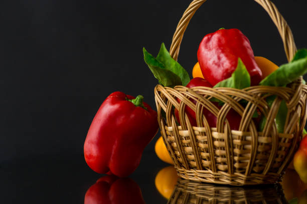 ripe red and yellow sweet peppers. Isolated on black background