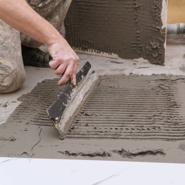 istock A construction worker applies cement for laying floor ceramic tiles with special spatula 2178094611