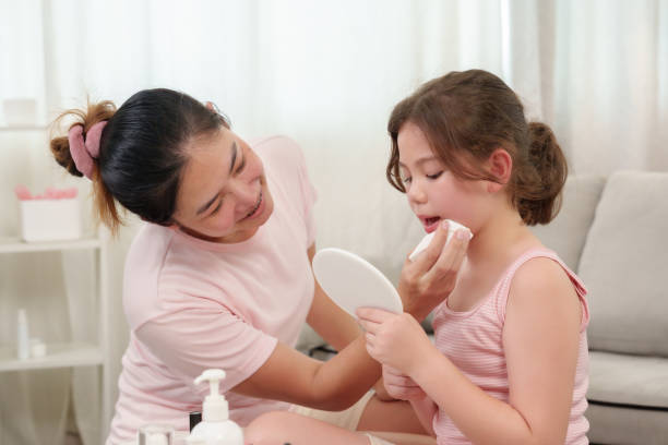 istock Mother lovingly helps daughter wipe makeup during a playful beauty session. Both share smiles, highlighting a heartwarming bonding moment as they enjoy a self-care routine together. 2178096266
