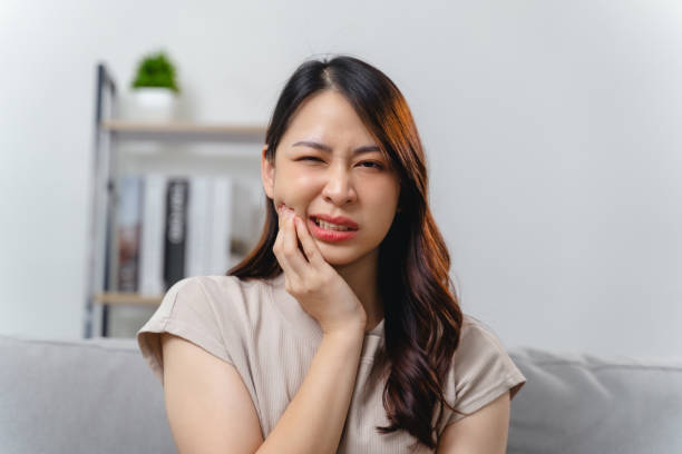 istock A woman with a toothache is sitting on a couch 2178097286