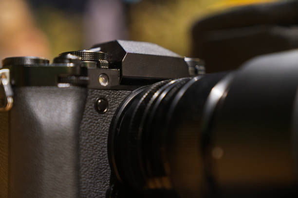 A camera lens is shown in a close up. The lens is black and has a black rubber grip