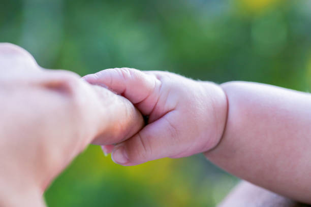 Toddler baby's hand on a beige blanket, close-up