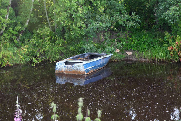 old blue boat on the bank of a small river