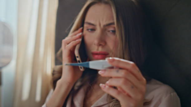 istock Calling lady measuring temperature feeling unwell at bed closeup. Sick woman 2178101823