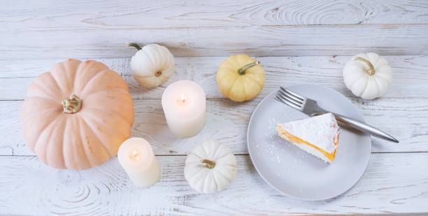 istock Pumpkin pie on a white wooden background with a burning candle 2178108571