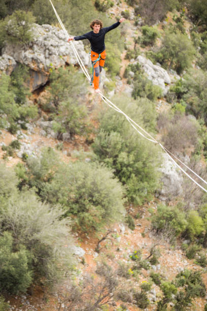 istock A tightrope walker walks along a cable stretched over a canyon. 2178108863
