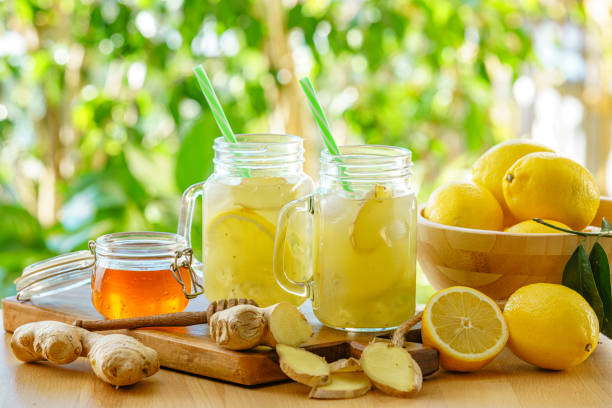 Mason jar glasses with ginger and lemon infused water on garden table