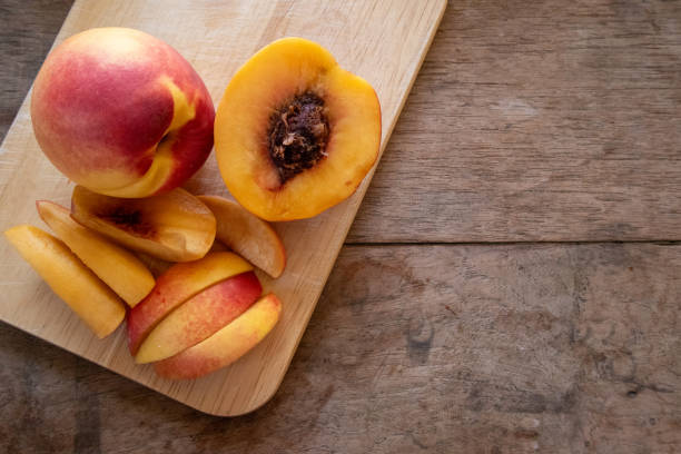 istock Fresh peaches from the orchard, both whole and sliced for immediate consumption, are on a wooden table. Peaches are a sweet and tangy fruit rich in antioxidants that help nourish the skin, making it smoother, softer, and more hydrated. 2178115734