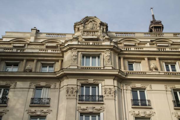 Close-up view of an ornate building facade with detailed architectural elements, Paris, France. Eiffel Tower in the background.