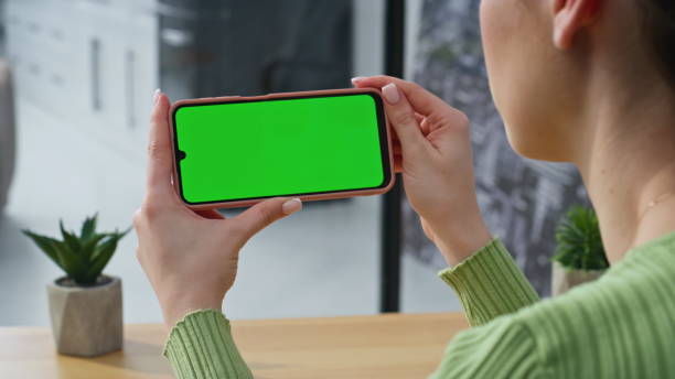 istock Unrecognizable lady holding chromakey mobile phone watching at home closeup 2178130389