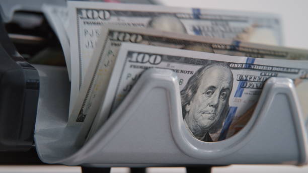 istock Modern automatic machine counting dollar bills denomination of hundred closeup 2178131823