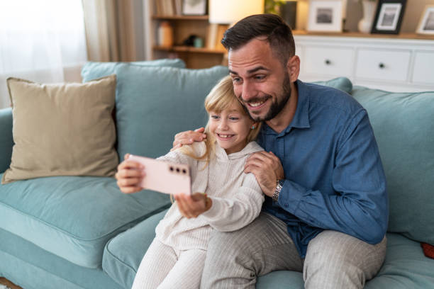 istock Dad and his little daughter taking selfie while enjoying at cozy home 2178135488