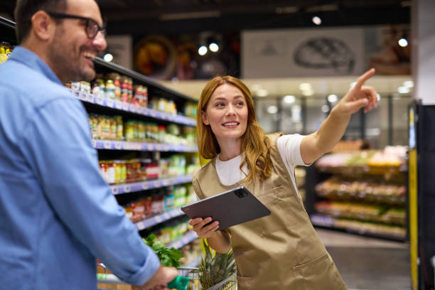 istock Man talking to female worker while shopping in supermarket 2178135536