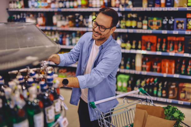 istock Man at the supermarket looking for some alcohol 2178135563