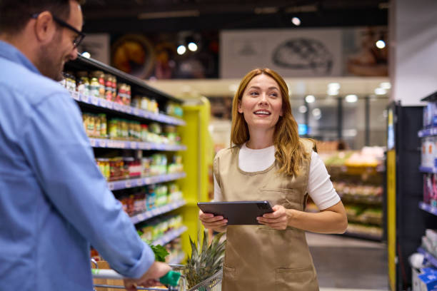 istock Man talking to female worker while shopping in supermarket 2178135617