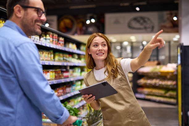istock Man talking to female worker while shopping in supermarket 2178135637