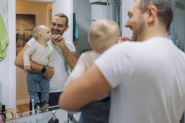 istock Young father brushing his son's teeth at bathroom 2178137166