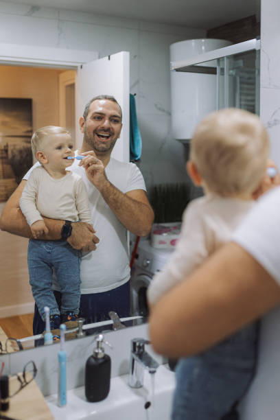 istock Young father brushing his son's teeth at bathroom 2178137168