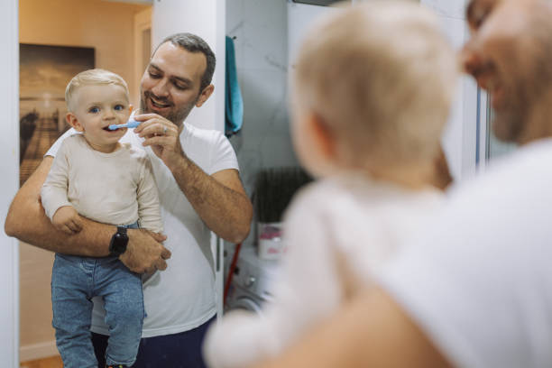 istock Young father brushing his son's teeth at bathroom 2178137184