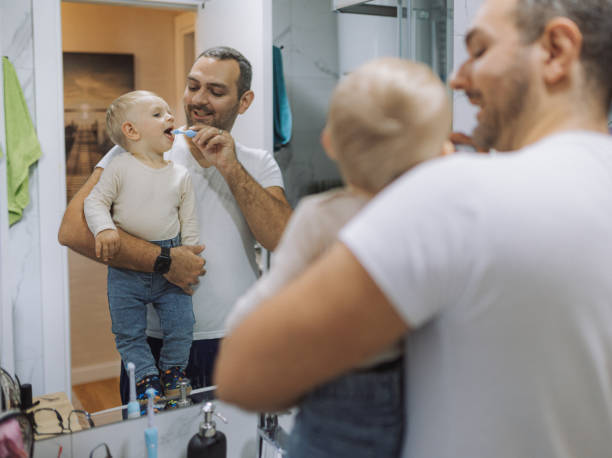 istock Young father brushing his son's teeth at bathroom 2178137204
