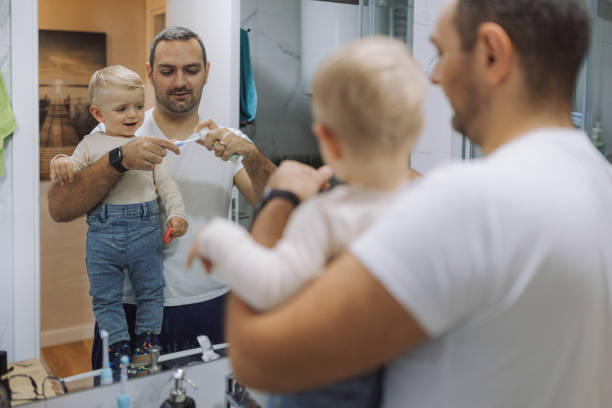 istock Young father brushing his son's teeth at bathroom 2178137224