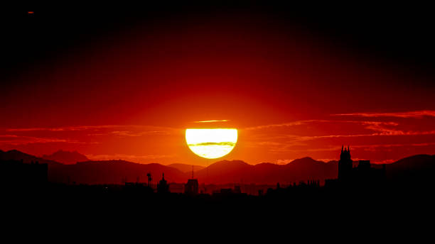 Panoramic view of the skyline of Madrid with the sun setting behind the mountains stock photo