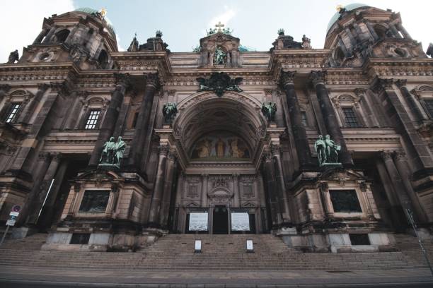 Berlin, Germany – June 13, 2024: Low-angle view of the Berlin Cathedral, showcasing its intricate architectural details and statues against a clear sky.