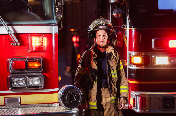 istock Female firefighter in protective gear at night 2178143640