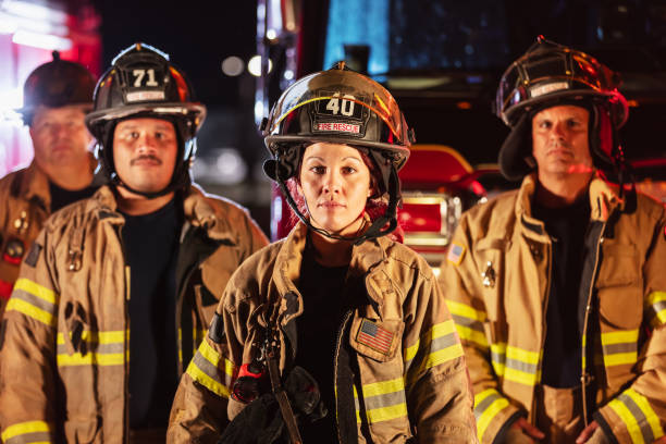 istock Female firefighter with group of firemen at night 2178143649