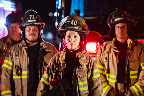 istock Female firefighter with group of firemen at night 2178143651