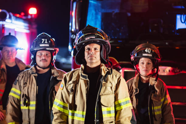 istock Multiracial group of firefighters by firetrucks at night 2178143654