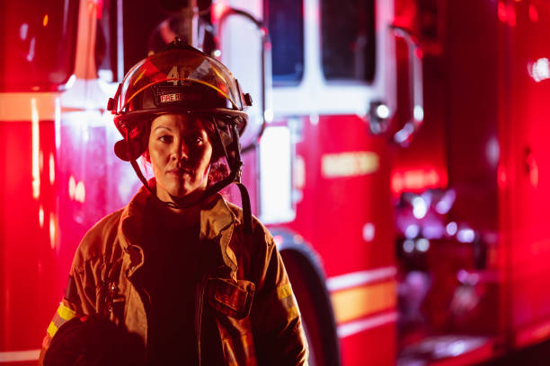 istock Female firefighter in protective gear  at night 2178143656