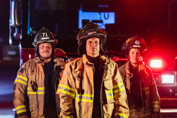 istock Multiracial group of firefighters by firetrucks at night 2178143657