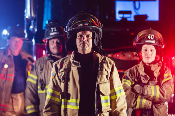 istock Multiracial group of firefighters by firetrucks at night 2178143661