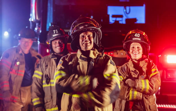 istock Multiracial group of firefighters by firetrucks at night 2178143663