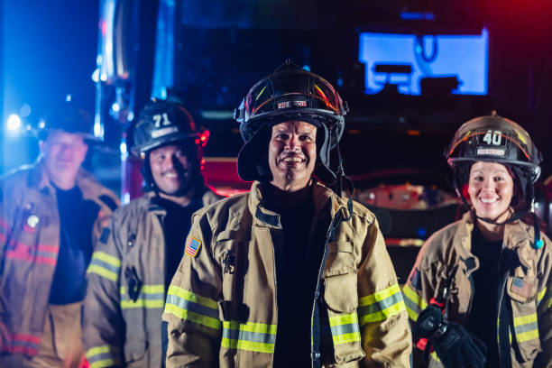 istock Multiracial group of firefighters by firetrucks at night 2178143667
