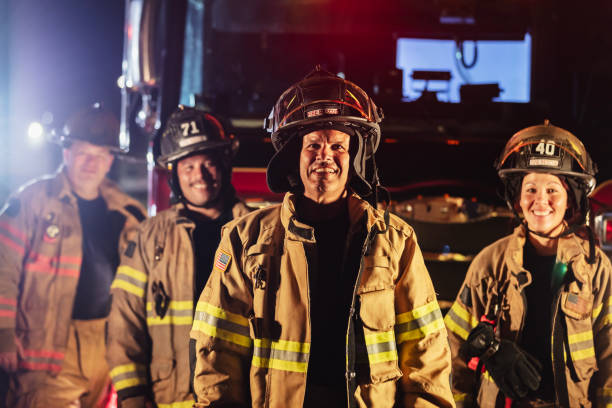 istock Multiracial group of firefighters by firetrucks at night 2178143672
