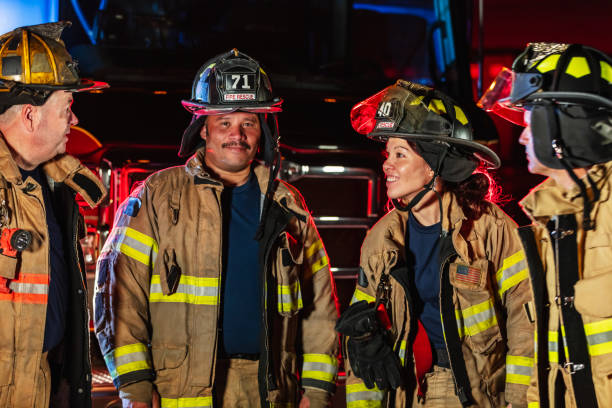 istock Multiracial group of firefighters by firetrucks at night 2178143676