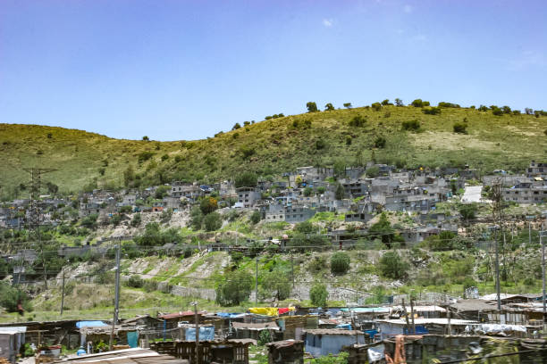 Crumbling concrete square buildings on the outskirts of Mexico City, built into the side of hills The suburbs on the outskirts of Mexico City are characterized by crumbling concrete square buildings precariously built into the sides of steep hills. These weathered architectural structures form dense, stacked residential areas, reflecting the urban sprawl and informal housing common in the region poverty mexico environment slum stock pictures, royalty-free photos & images