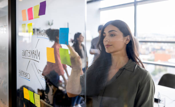 istock Businesswoman brainstorming at the office and posting ideas on sticky notes 2178146304