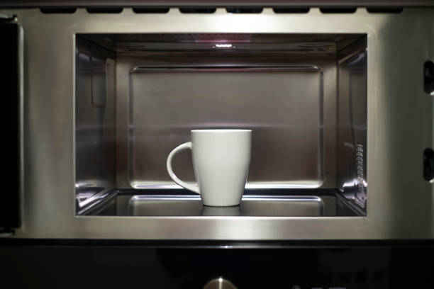 istock a white ceramic cup inside a stainless steel microwave, a mug heating up in the kitchen microwave 2178146389