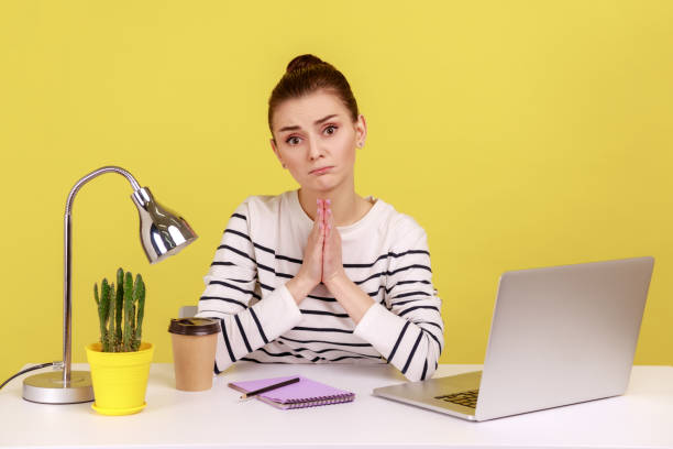 istock Attractive woman manager sitting at workplace and holding hands in praying gesture, asking heartily. 2178146838