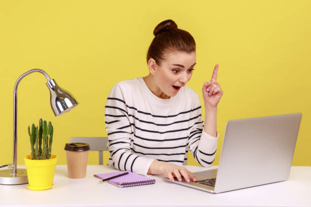 istock Woman looking surprised by genius idea, raising finger up inspired while working on laptop. 2178146843