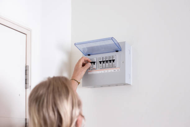 istock A man turns on a switch on an electrical panel in a room. Distributor Electricity 2178147303